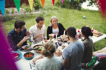 Blick von oben auf Freunde, die das Abendessen auf einer Gartenparty genießen - MASF02387