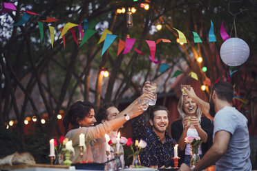 Happy friends toasting drinks while enjoying at garden party - MASF02389