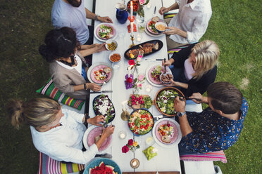 Blick von oben auf multiethnische Freunde, die eine Mahlzeit bei einer Gartenparty genießen - MASF02393