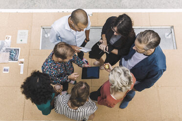 High angle view of businessman discussing over digital tablet with colleagues in portable office truck - MASF02407