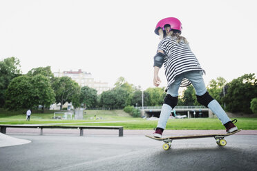 Full length of girl skateboarding at park against clear sky - MASF02459