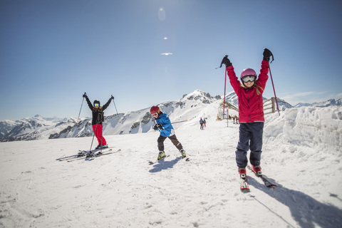 Familie in voller Länge beim Skifahren gegen den klaren Himmel, lizenzfreies Stockfoto