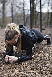 Female athlete performing plank position in forest - MASF02506