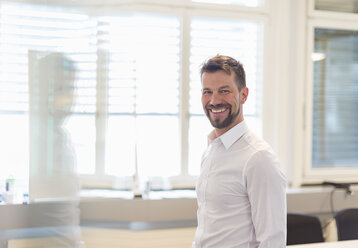 Portrait of a successful businessman standing in office - DIGF03916