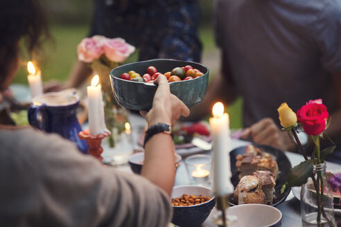 Cropped image of woman serving food to friends at garden party - MASF02512