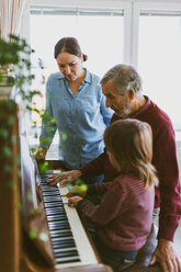 Woman looking at boy and great grandfather playing piano - MASF02620
