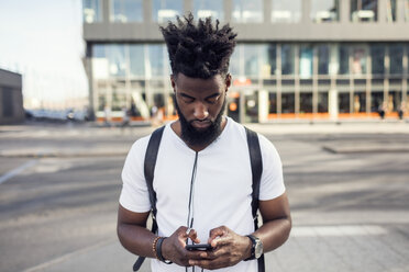 Young man using phone while in city - MASF02627