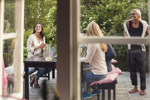 Frauen und junges Mädchen am Esstisch vom Fenster aus gesehen - MASF02642