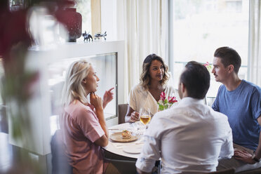 Business colleagues talking while eating lunch at restaurant during meeting - MASF02660