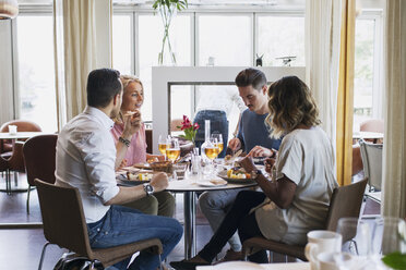 Business friends sitting at restaurant during lunch - MASF02661