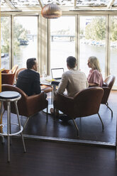 Business colleagues sitting with laptop during meeting at restaurant - MASF02664