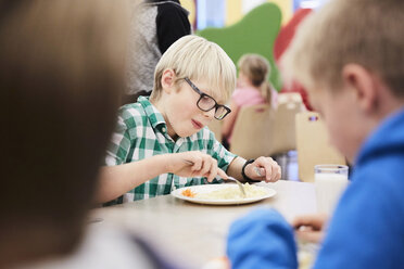 Junge beim Mittagessen am Tisch in der Schulcafeteria - MASF02676