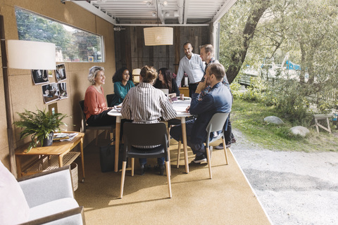 Geschäftskollegen besprechen die Strategie in einem mobilen Bürofahrzeug, lizenzfreies Stockfoto