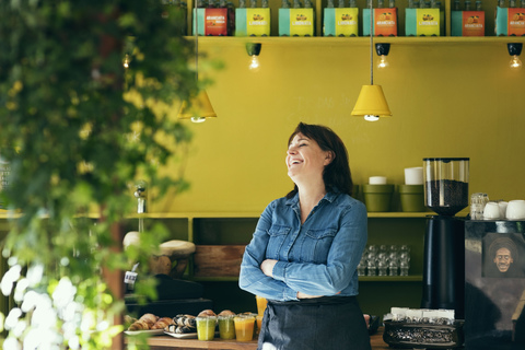 Lächelnde Besitzerin im Café stehend, lizenzfreies Stockfoto