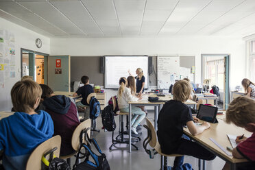 Lehrer erklärt Studenten durch Whiteboard im Klassenzimmer - MASF02772