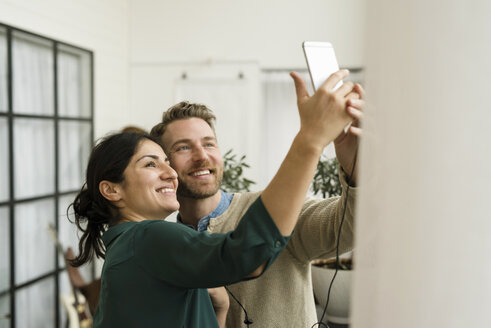 Lächelnde Geschäftsleute, die ein Selfie machen, während sie im Büro stehen - MASF02809
