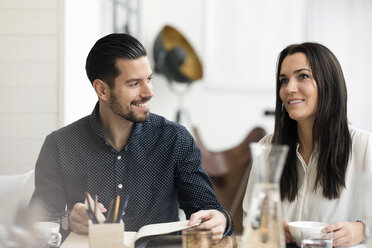 Lächelnde Geschäftsleute unterhalten sich während eines Treffens am Tisch im Büro - MASF02812