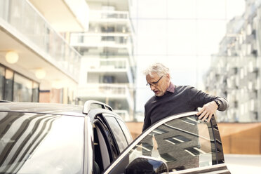 Älterer Mann beim Aussteigen aus einem Auto in der Stadt - MASF02839
