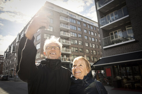 Älteres Paar, das ein Selfie mit seinem Smartphone macht, während es in der Stadt steht - MASF02840