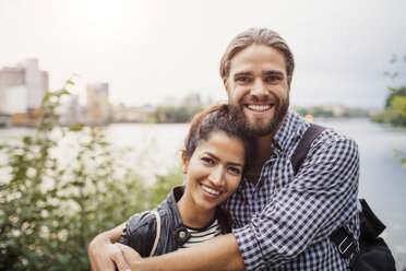 Portrait of smiling couple standing against river - MASF02940