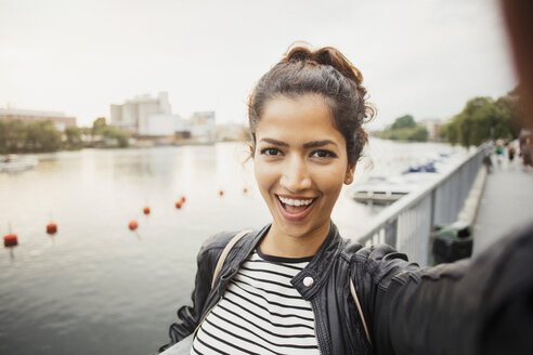 Porträt einer lächelnden Frau, die am Fluss in der Stadt steht - MASF02941