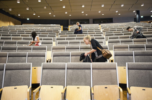 Junge Männer und Frauen verlassen den Hörsaal nach dem Seminar - MASF02950