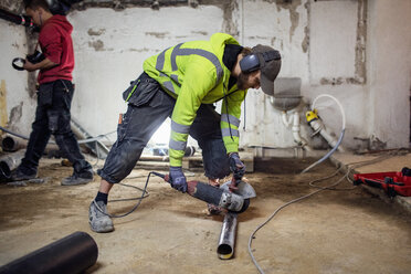 Klempner arbeiten an Rohren in einem verlassenen Keller - MASF02972