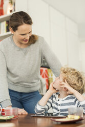 Mutter und Sohn unterhalten sich am Esstisch im Wohnzimmer - MASF02979