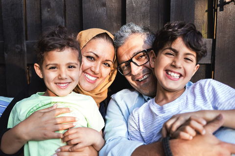 Porträt einer glücklichen Familie vor dem Haus, lizenzfreies Stockfoto