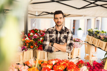 Porträt eines selbstbewussten männlichen Inhabers, der mit verschränkten Armen in einem Blumenladen steht - MASF02984