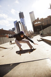 Mann vollführt Stunt mit Skateboard im Park - CAVF36303