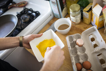 Cropped image of man beating eggs in kitchen - CAVF36356