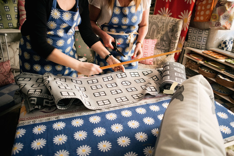 Mittelteil der Besitzer bei der Arbeit an Textilien im Stoffgeschäft, lizenzfreies Stockfoto