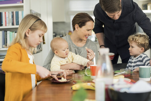 Glückliche Familie beim Frühstück am Wohnzimmertisch - MASF03053