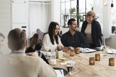 Happy business people discussing at decorated table during meeting in office - MASF03079