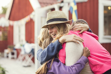 Happy friends embracing in back yard - MASF03085