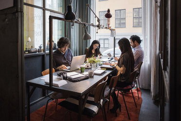 Männliche und weibliche Blogger arbeiten am Tisch in einem modernen Büro - MASF03091