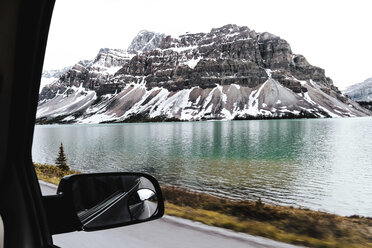 Mountain amidst sea against clear sky at Jasper National Park seen through car window - CAVF36500