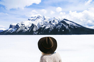 Rear view of woman in fedora hat looking at view against cloudy sky - CAVF36513