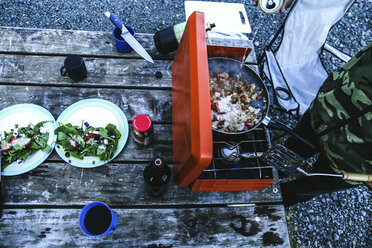 Hoher Blickwinkel des Mannes bei der Zubereitung von Essen auf dem Grill auf dem Campingplatz - CAVF36534