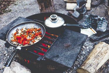 High angle view of food in cooking pan on fire pit at campsite - CAVF36559