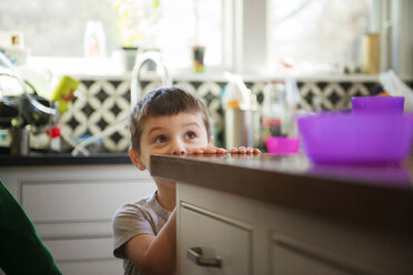 Boy hiding and playing in kitchen at home - CAVF36620