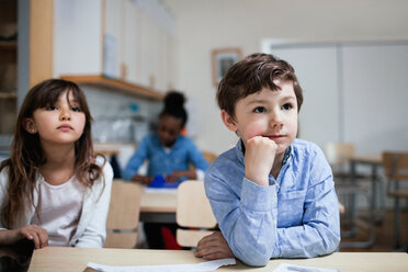 Konzentrierte Kinder sitzen am Schreibtisch im Klassenzimmer - MASF03142