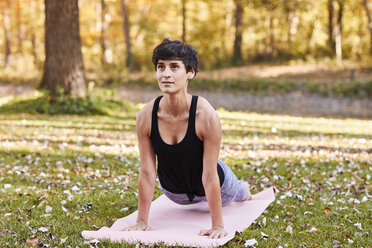 Mid erwachsene Frau im Wald übt Yoga, Kobra-Pose - SHOF00004