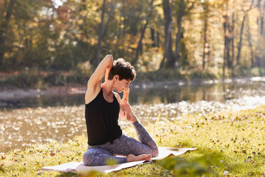 Mid adult woman in forest practicing yoga - SHOF00005