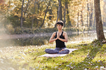 Mittlere erwachsene Frau im Wald, die Yoga und Meditation praktiziert - SHOF00006