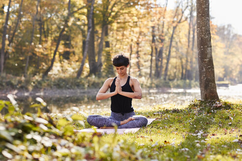 Mittlere erwachsene Frau im Wald, die Yoga und Meditation praktiziert - SHOF00007