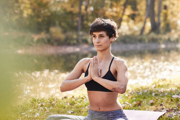 Mittlere erwachsene Frau im Wald, die Yoga und Meditation praktiziert - SHOF00008