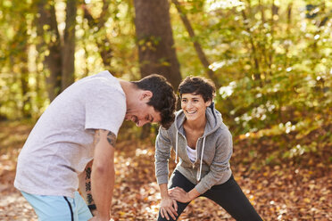 Couple stretching in autumn forest - SHOF00020