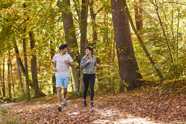 Pärchen joggt auf herbstlichem Waldweg - SHOF00025